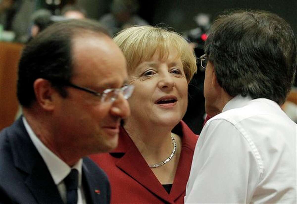 German Chancellor Angela Merkel, center, is greeted by Belgian Prime Minister Elio Di Rupo, right, as French President Francois Hollande, left, walks by during a round table meeting at an EU summit in Brussels, Thursday, Oct. 24, 2013. A two-day summit meeting of EU leaders is likely to be diverted from its official agenda, economic recovery and migration, after German Chancellor Angela Merkel complained to U.S. President Barack Obama that U.S. intelligence may have monitored her mobile phone. (AP Photo/Yves Logghe)