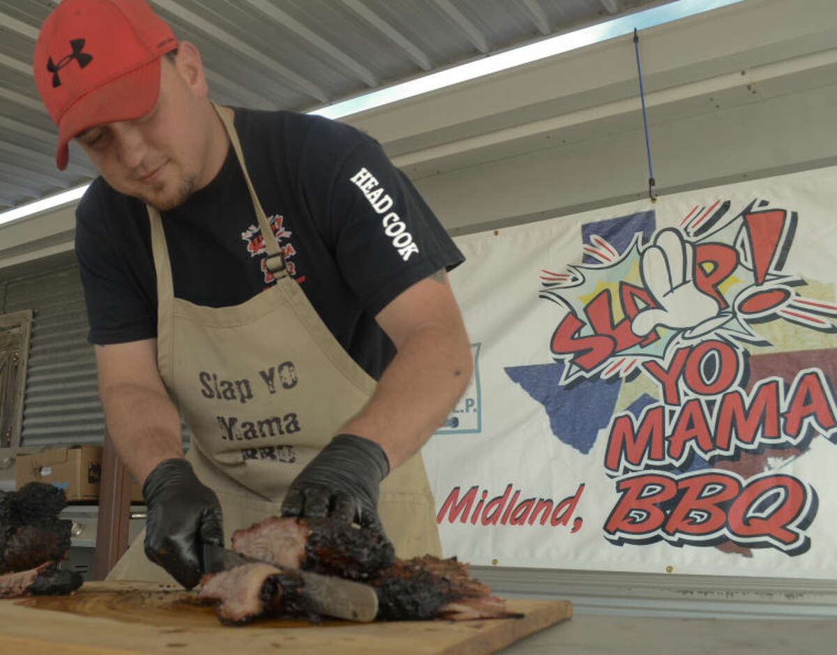 Paul Greene leads his cooking team "Slap Yo Mama BBQ" as he prepares food Friday at a benefit for Boys and Girls Club. Tim Fischer\Reporter-Telegram