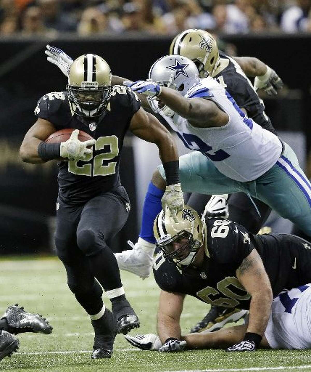 New Orleans running back Mark Ingram (22) rushes past Dallas Cowboys defensive end Jarius Wynn (92) in the second half of Sunday’s game in New Orleans. Dave Martin/AP
