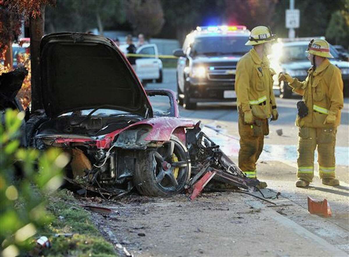 Sheriff's deputies work near the wreckage of a Porsche that crashed into a light pole on Hercules Street near Kelly Johnson Parkway in Valencia, Calif., on Saturday, Nov. 30, 2013. A publicist for actor Paul Walker says the star of the "Fast & Furious" movie series died in the crash north of Los Angeles. He was 40. Ame Van Iden says Walker died Saturday afternoon. No further details were released. (AP Photo/The Santa Clarita Valley Signal, Dan Watson)