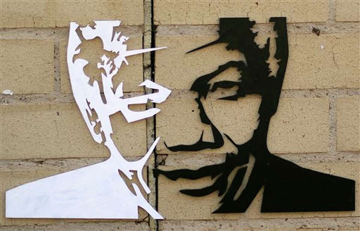 FILE - In this July 16, 2013 file photo, a portrait of former South African President Nelson Mandela is attached to a wall outside the Mediclinic Heart Hospital where he was being treated in Pretoria, South Africa. On Thursday, Dec. 5, 2013, Mandela died at the age of 95. (AP Photo/Themba Hadebe)