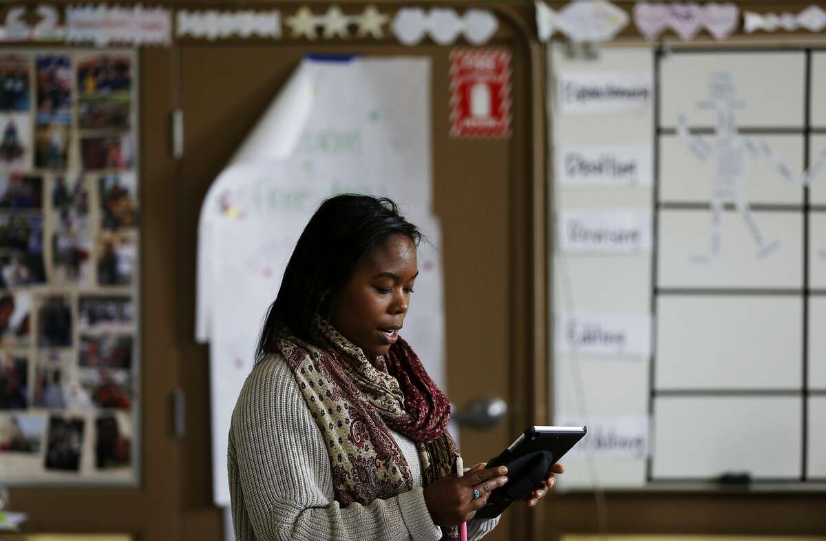 Kamaria Carnes of Teach for America reads off a tablet during her 8th grade English Language Arts class at Everett Middle School in San Francisco, California, on Wednesday, May 11, 2016.