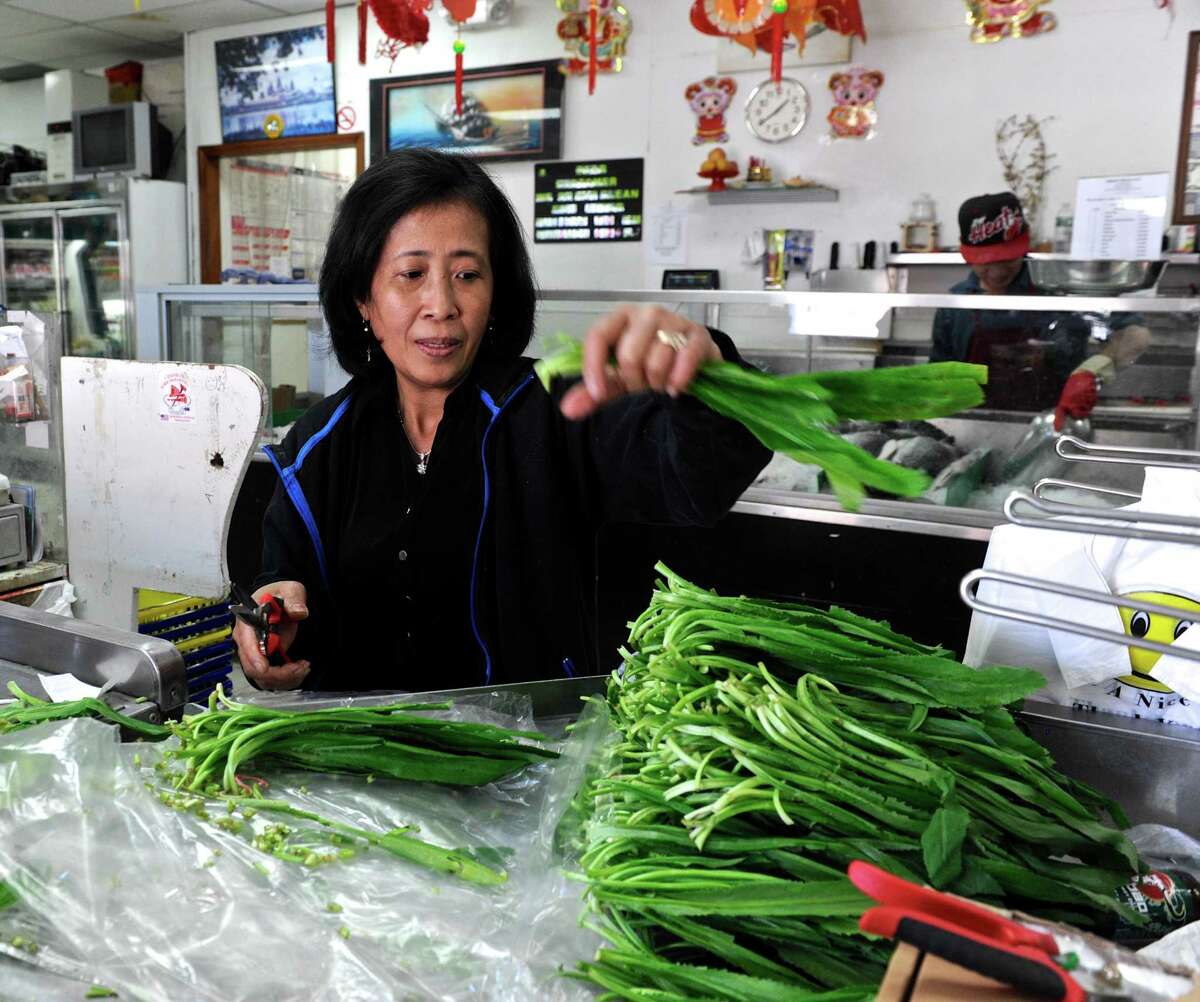 Dung Son cuts ngō gai, an herb used in soups or salads, at the Atlantic Market, an Asian food market, on Main Street in Danbury. According to a survey by the financial website WalletHub, Danbury is the 21st most diverse city in the country, ranked just below San Francisco. Thursday, May 12, 2016, in Danbury, Conn.