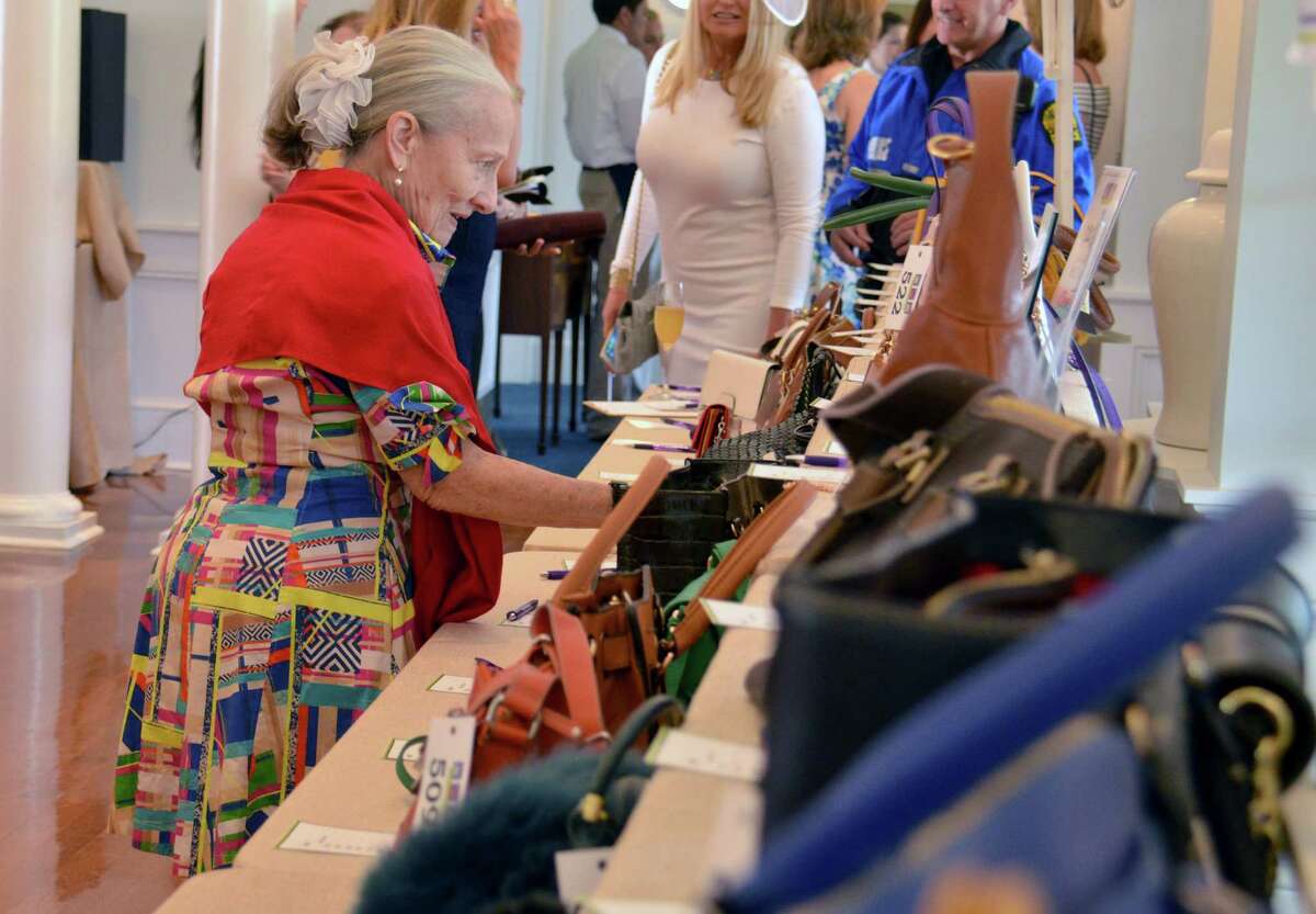 Betsy Ress of Greenwich, Conn. looks at bags up for bid at the Old Bags Luncheon at the Belle Haven Club in Greenwich, Conn. on Thursday, May 12, 2016. All proceeds from the event's bag auctions will help fund the Greenwich YWCA Domestic Abuse Services.