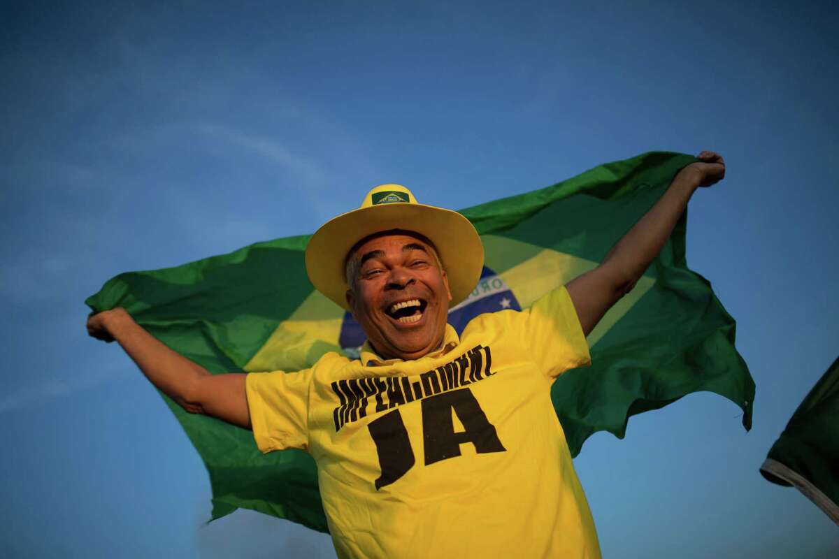 An anti-government demonstrator celebrates the result of the impeachment process outside Congress in Brasilia, Brazil, Thursday, May 12, 2016. Brazil's Senate voted Thursday to impeach President Dilma Rousseff just months before it hosts the Summer Olympics. Rousseff's ally-turned-enemy, Vice President Michel Temer, will take over as acting president later Thursday while she is suspended. The Senate has 180 days to conduct a trial and decide whether Rousseff should be permanently removed from office. (AP Photo/Felipe Dana)