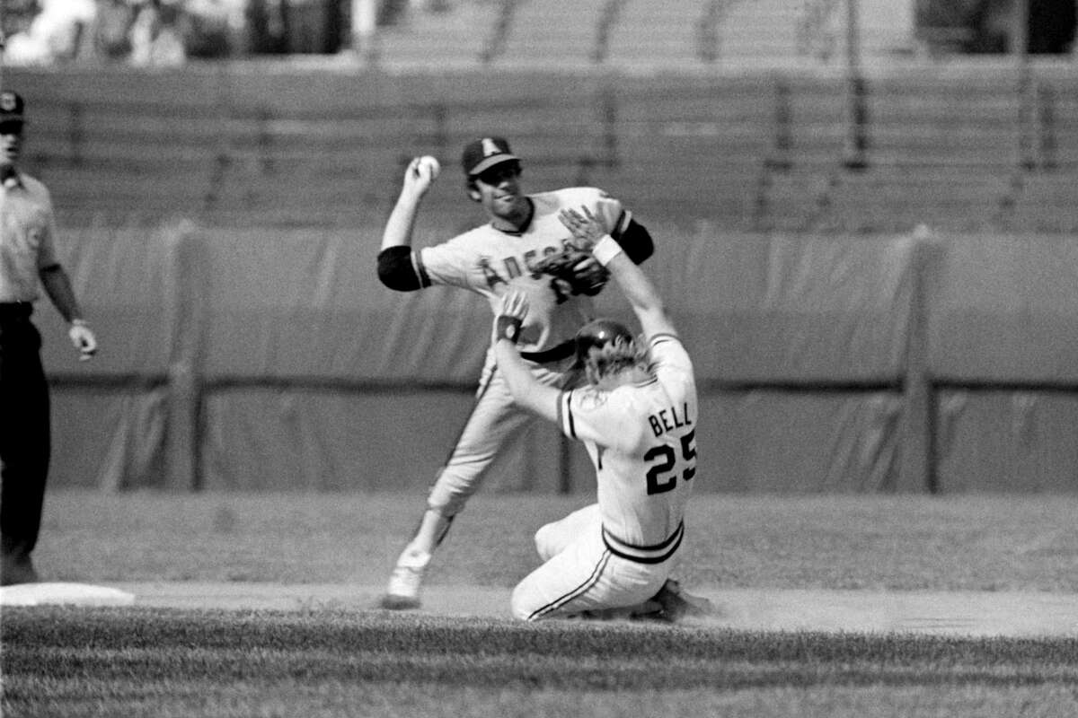 Shortstop Bobby Valentine #13 (right), of the California Angels, throws the ball to first base as Buddy Bell #25 (center), of the Cleveland Indians, is out trying to break up a double play at second base during a game on July 8, 1973 at Municipal Stadium in Cleveland, Ohio.