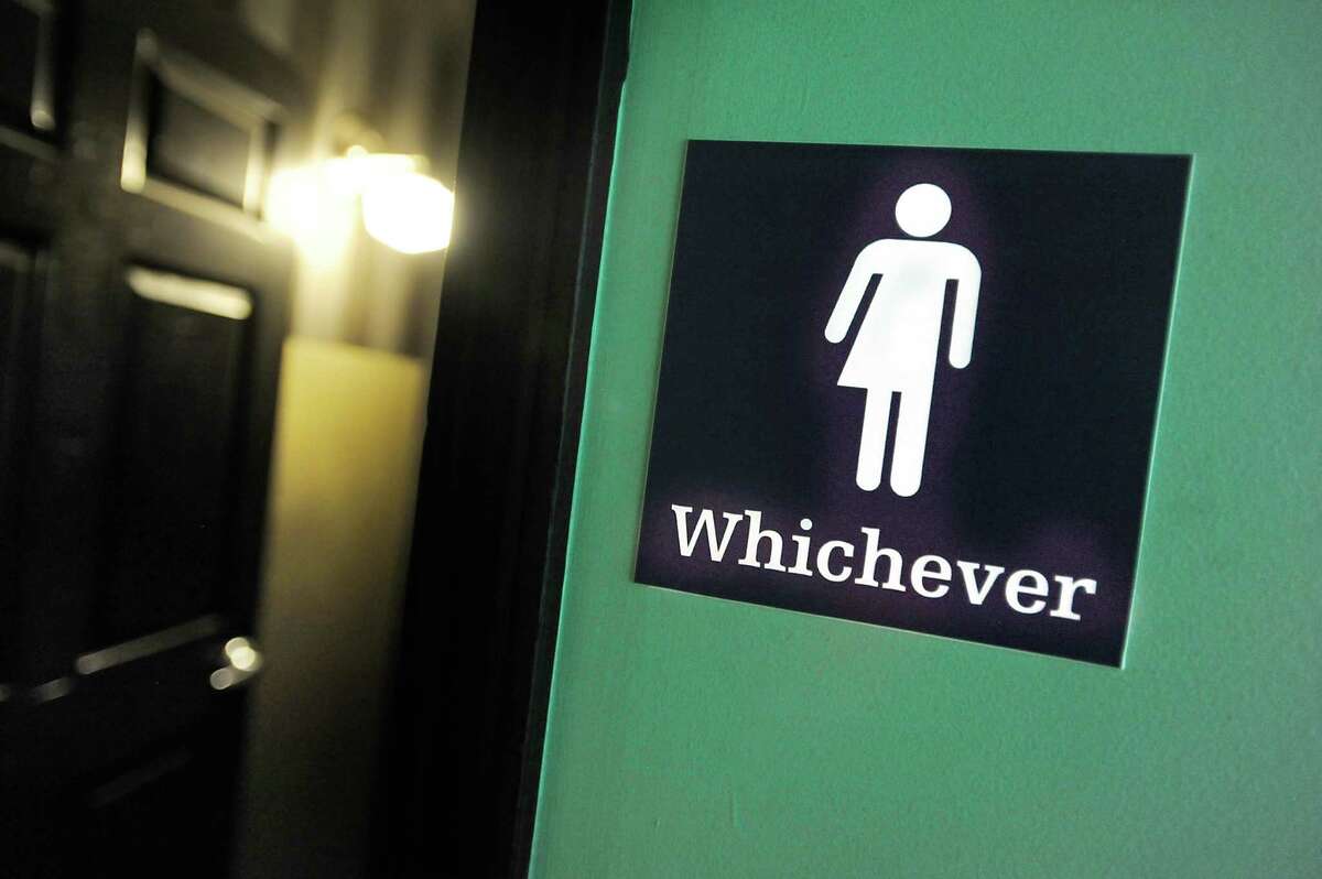A gender neutral sign is posted outside a bathrooms at Oval Park Grill in Durham, N.C.