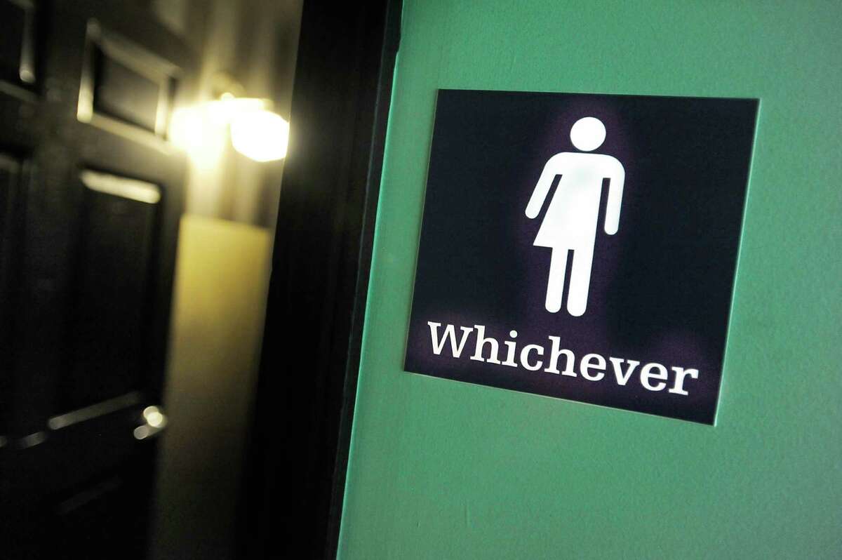A gender neutral sign is posted outside a bathroom at Oval Park Grill in Durham, N.C.  (Photo by Sara D. Davis/Getty Images)