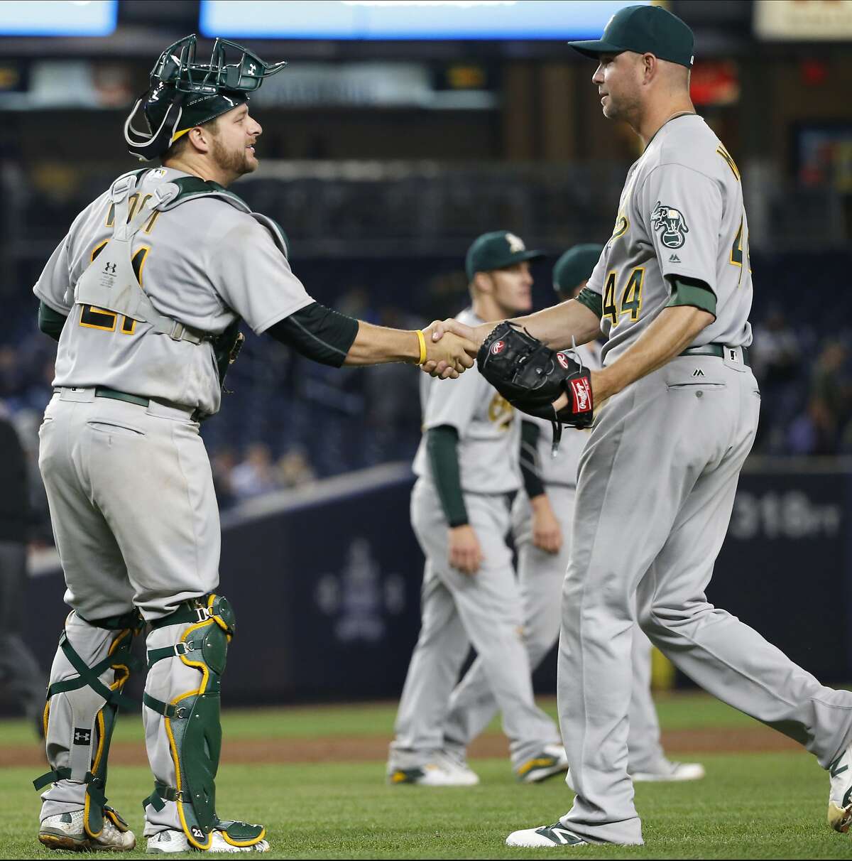 Oakland Athletics catcher Stephen Vogt, left, congratulates relief pitcher Ryan Madson (44) after the Athletics' 7-3 victory over the New York Yankees in a baseball game in New York, Thursday, April 21, 2016. (AP Photo/Kathy Willens)