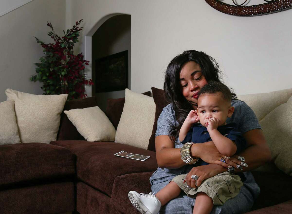 Candice Hinton, holding her son, Rodrin Jr., said an investigator assigned to her husband's death has only given her a 'very vague' account of what happened at the Harris County Jail. ﻿