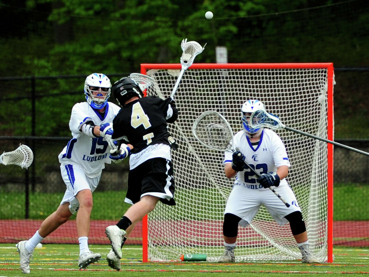 Trumbull's Danny Hoffmann attempts a goal shot as Fairfield Ludlowe's Joseph Casucci, left, and goalie Carter Leibrock defend during boys lacrosse action in Fairfield, Conn., on Saturday May 14, 2016.