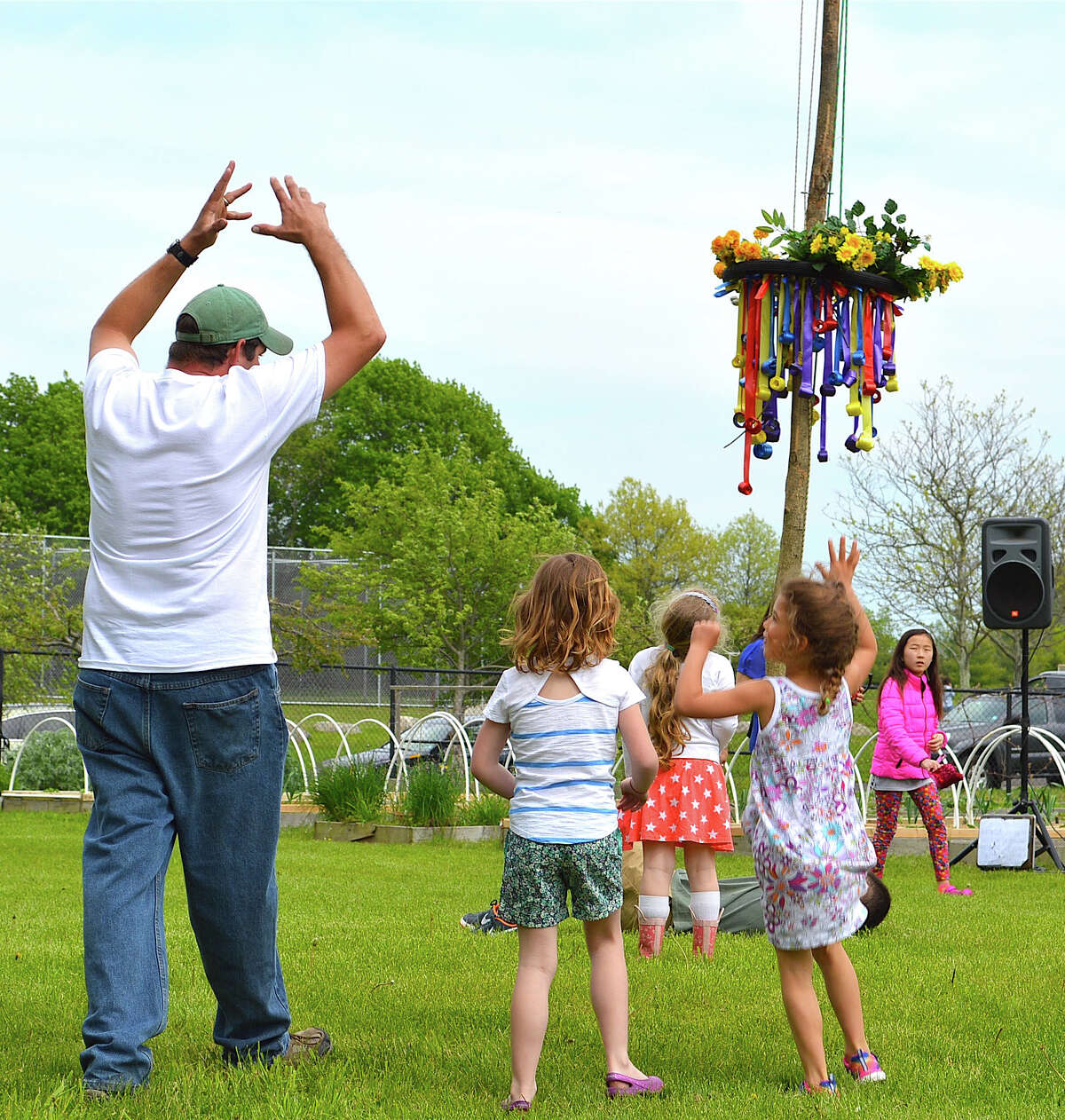 Mike Aitkenhead, steward of Wakeman Town Farm, shows youngsters how the maypole dance works during its GreenDay program.