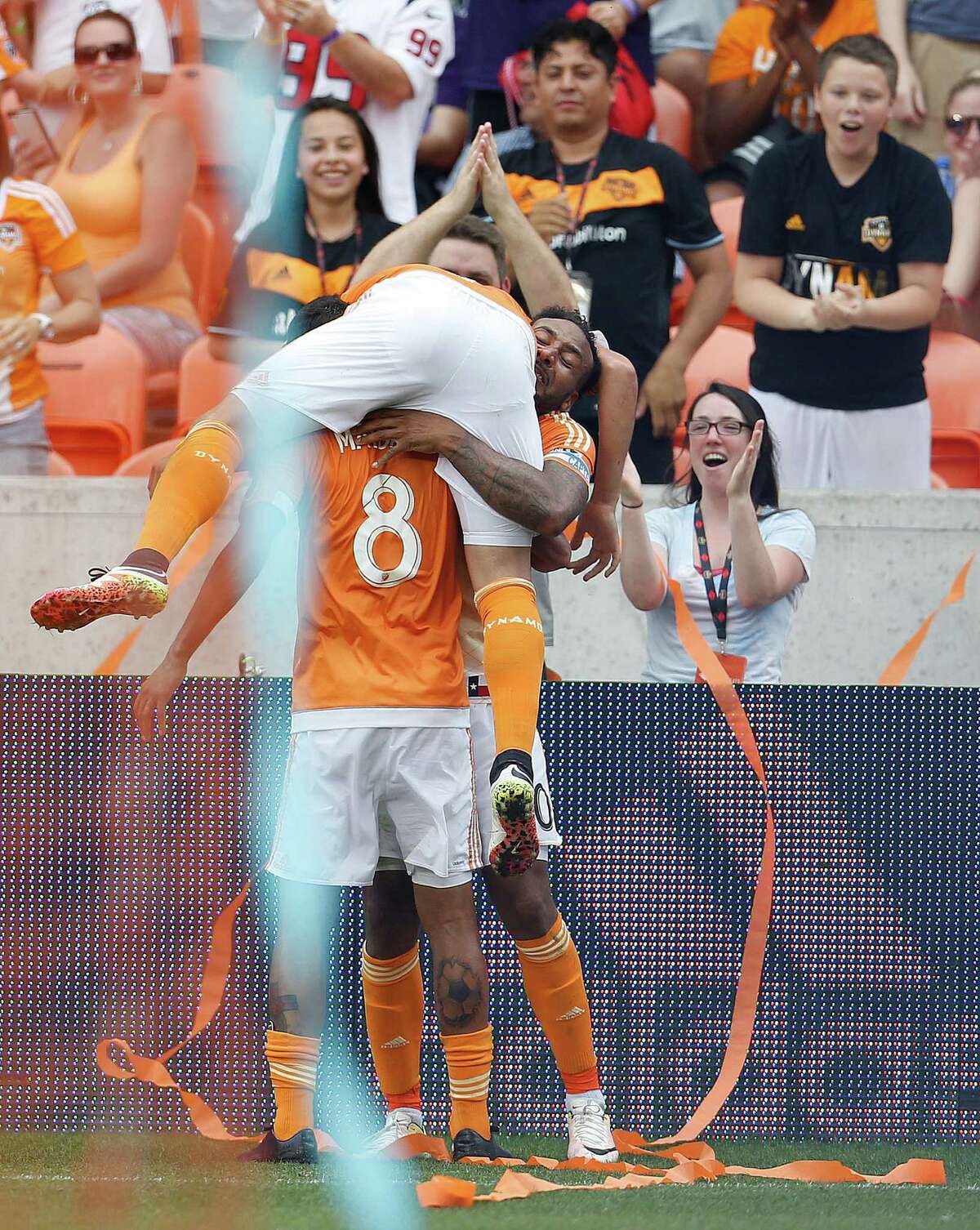 Houston Dynamo forward Erick Torres (9) jumps onto Giles Barnes (10) and Cristian Maidana (8) after Barnes scored a goal during the second half of an MLB soccer game at BBVA Compass Stadium, Sunday, May 15, 2016, in Houston. Dynamo won the game 1-0.
