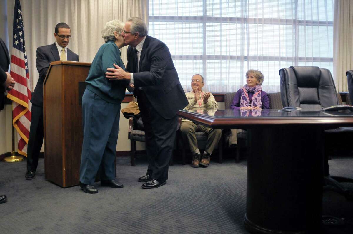 Marion Field of Troy gets a kiss from Troy Mayor Lou Rosamilia during an event at the FBI Albany Division headquarters on Monday, Dec. 9, 2013 in Albany, NY. Field was awarded the FBI Director's Community Leadership Award at the event. Also pictured is Andrew Vale, FBI special agent in charge, Albany Division. (Paul Buckowski / Times Union)