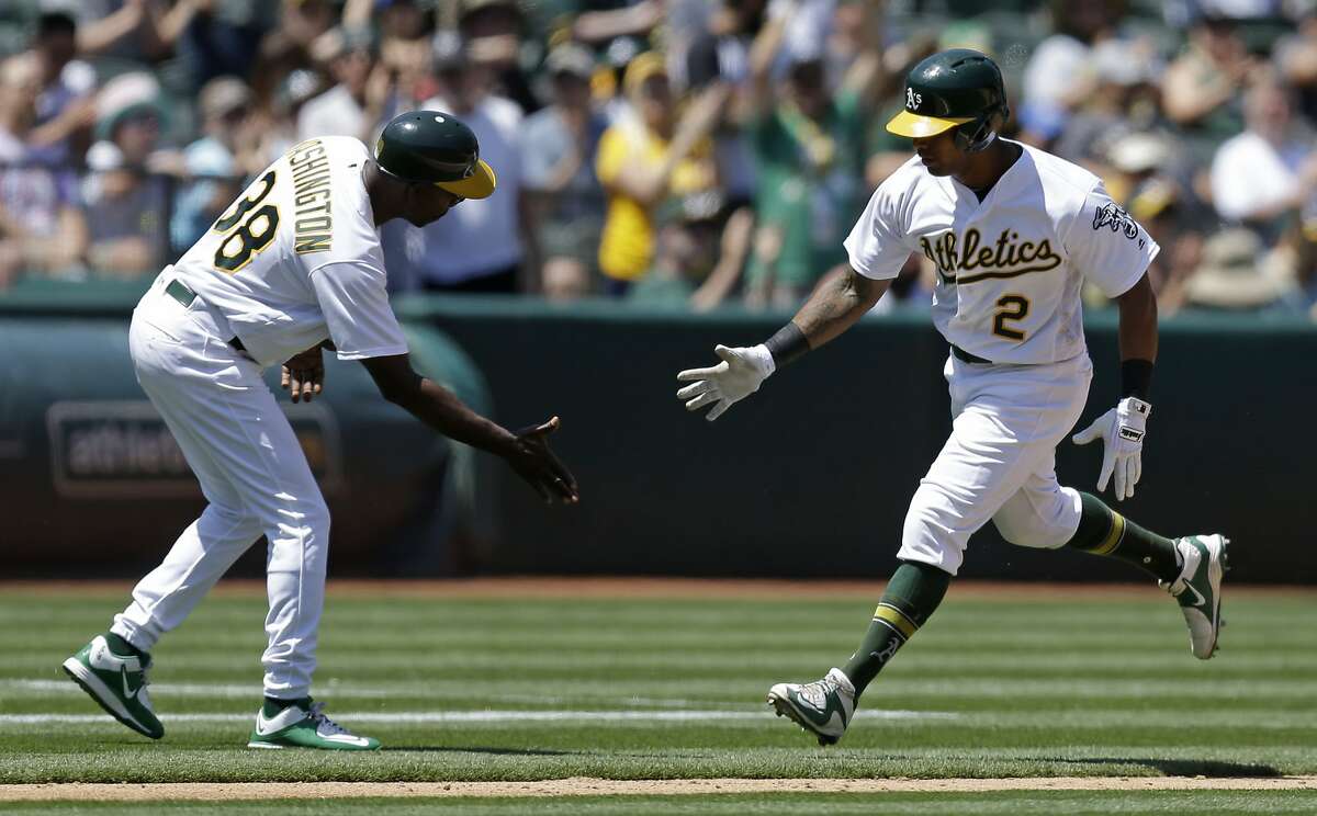 Oakland Athletics' Khris Davis, right, is congratulated by third base coach Ron Washington after hitting a home run off Texas Rangers' Martin Perez in the sixth inning of a baseball game, Wednesday, May 18, 2016, in Oakland, Calif. (AP Photo/Ben Margot)