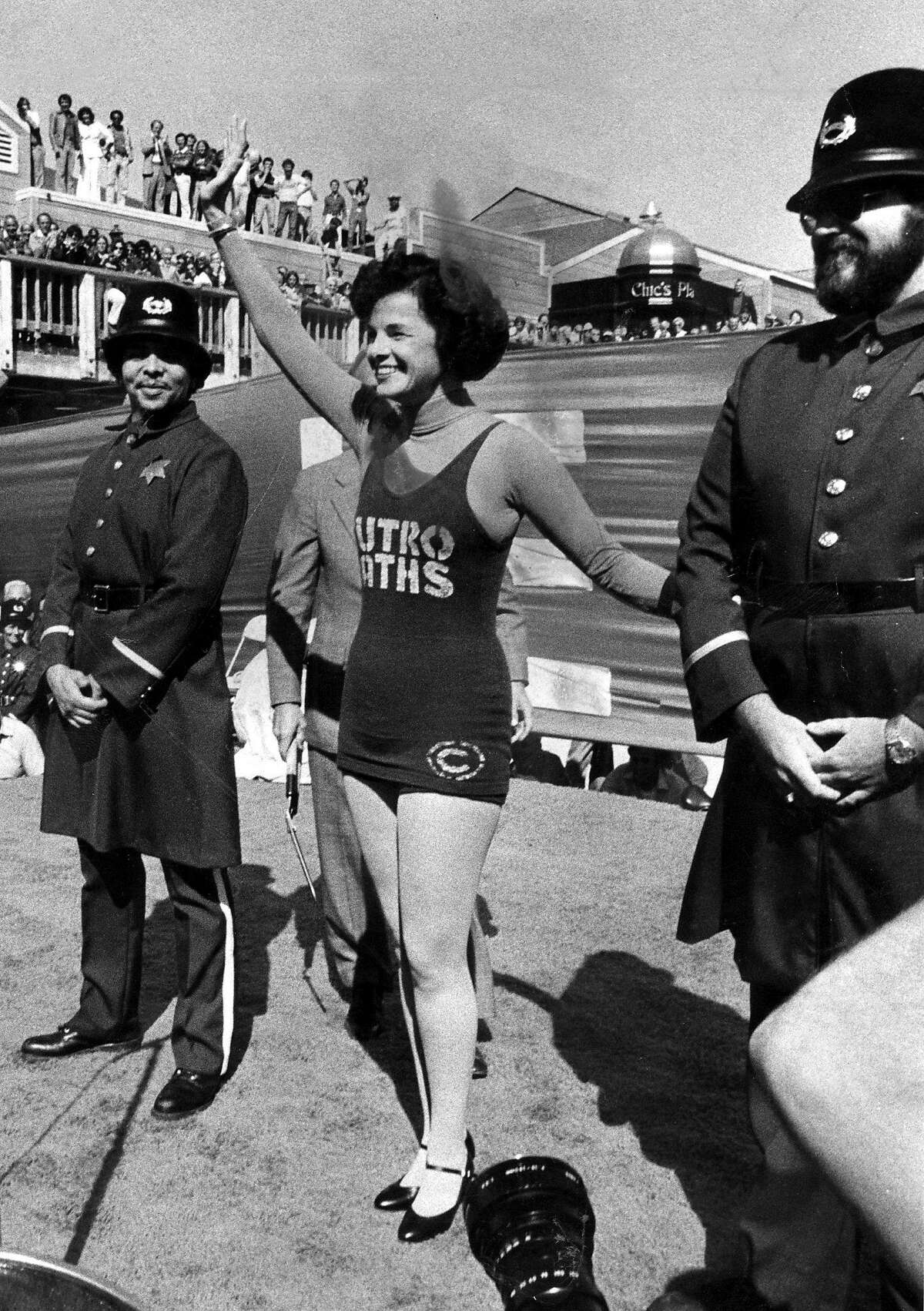 Supervisor Dianne Feinstein wearing a Sutro Baths tank suit, prepares to cut the ribbon at the opening of Pier 39 development.