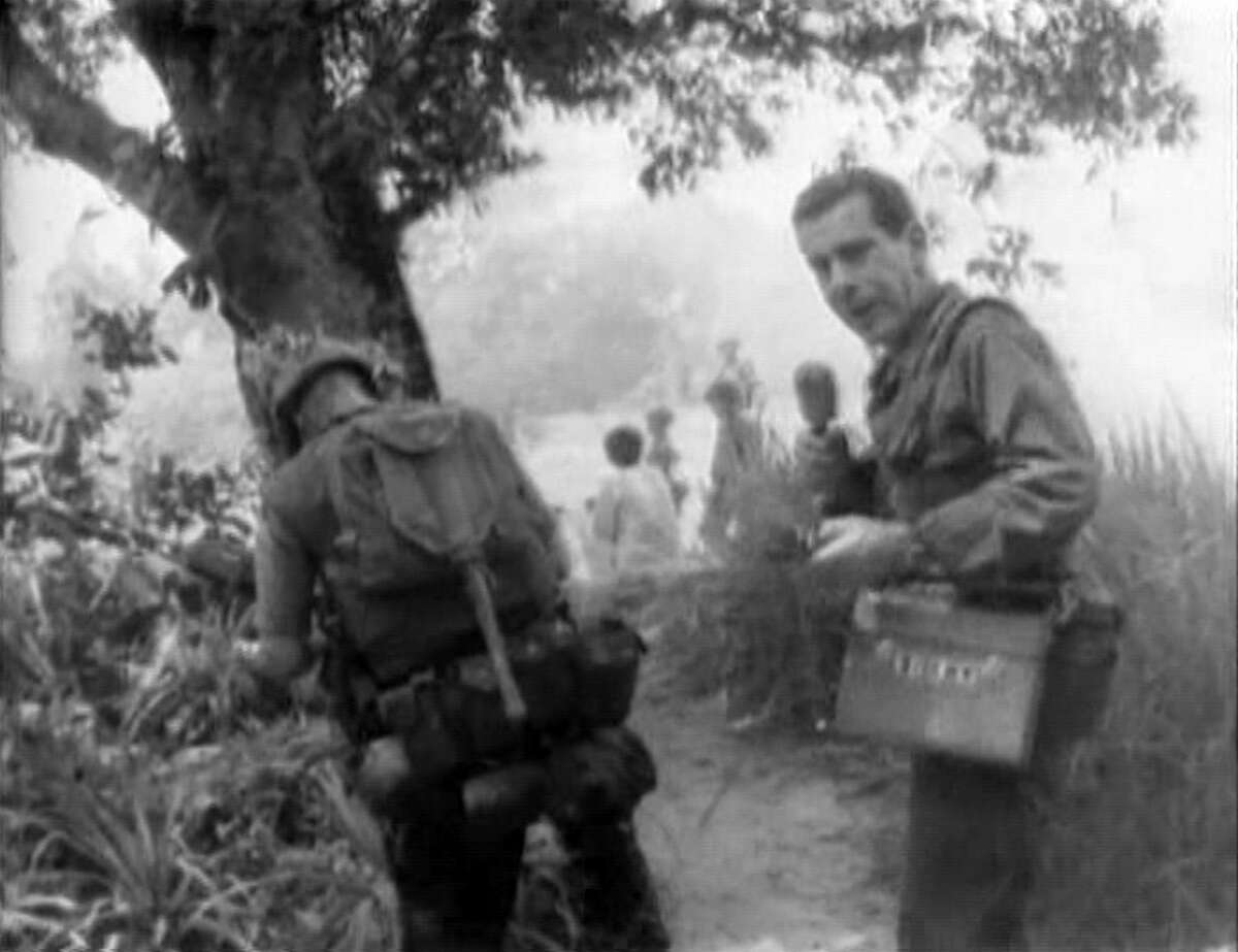 American news broadcaster Morley Safer, correspondent for CBS News, as Safer reports on the systematic burning of South Vietnamese villages by US Marines during the Vietnam War, Cam Ne, Vietnam, 1965. The broadcast showed US Marines igniting huts with Zippo lighters. Photo is a screen grab. (Photo by CBS via Getty Images)