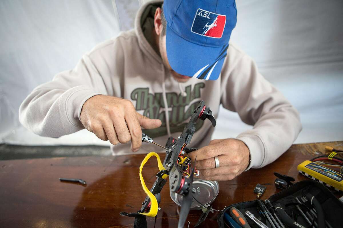 Jason Bouslaugh fine tunes his racing drone in the Drone Racing Tent as set up continues at the San Mateo Event Center for Maker Faire on Thursday, May 19, 2016.