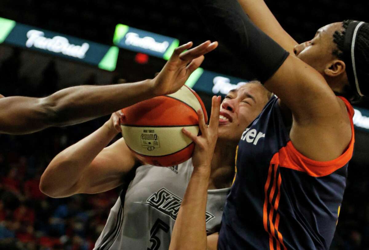 San Antonio Stars’ Dearica Hamby is trapped by the Connecticut Sun’s Kelsey Bone (right) and another Sun player at the AT&T Center on May 19, 2016.