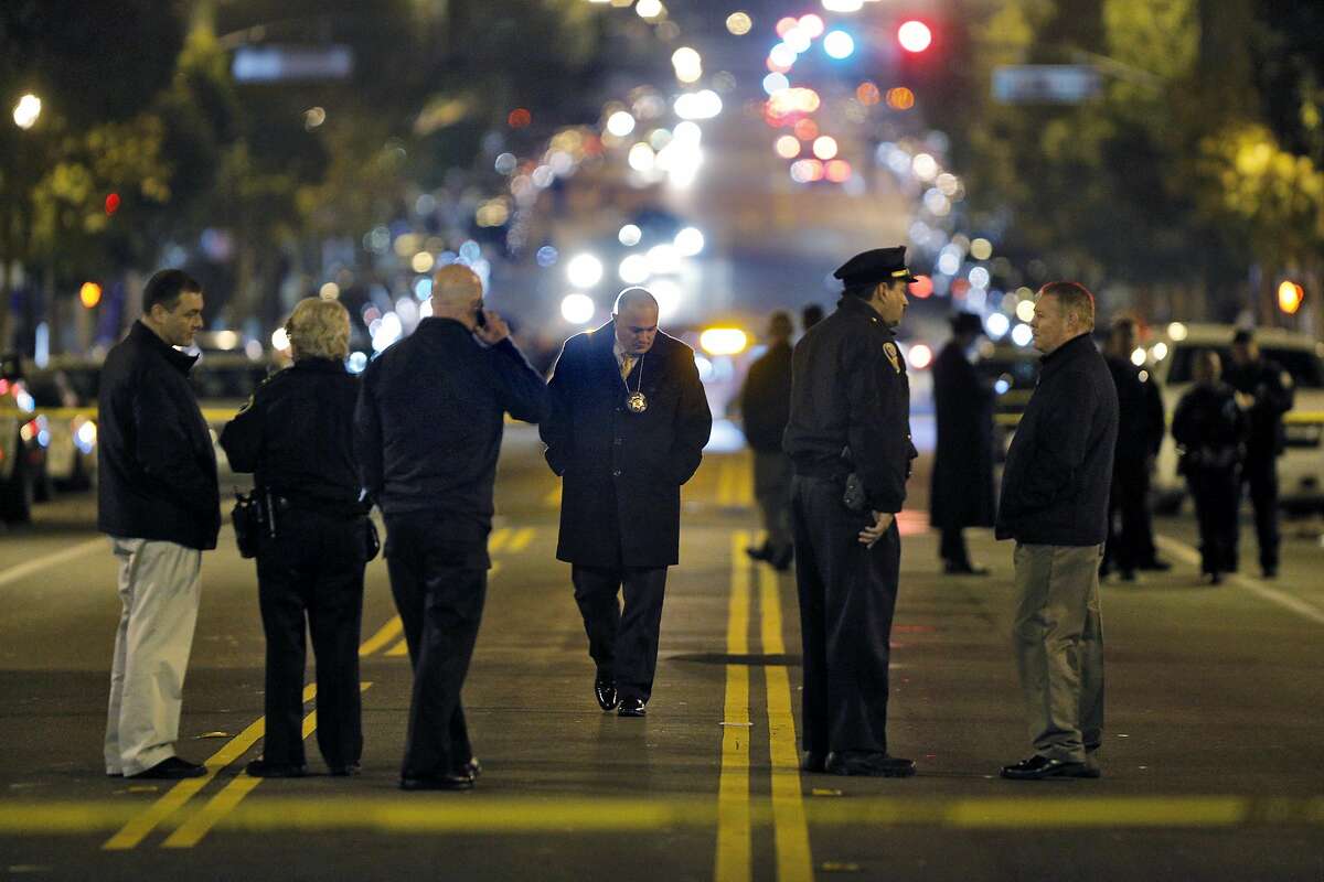 Police investigators gather on Valencia Street after an officer-involved shooting at the San Francisco Police Mission Station in San Francisco, Calif., on Sunday, January 4, 2015.