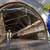A worker walks out of a massive autoclave that will be used to bake carbon fiber wings with super-heated pressure, during a tour of the new Boeing 777X Composite Wing Center a day ahead of its grand opening, Thursday, May 19, 2016, in Everett, Wash. The facility, which is still under construction, will manufacture the world's largest composite wings for Boeing's newest commercial jetliner, the 777X. The new $1 billion, 1 million square foot center is close to the widebody plant where the 777X will be assembled because the wings are the largest Boeing has ever built ?— 114 feet long and 23 feet wide. (AP Photo/Elaine Thompson)