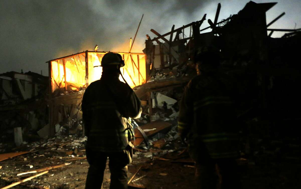 FILE - In this April 18, 2013, file photo, firefighters use flashlights to search a destroyed apartment complex near the West Fertilizer Co. plant that exploded in West, Texas. The Texas company that operated the fertilizer plant where a thunderous explosion in April killed 15 people is facing $118,300 in fines for two dozen serious safety violations, including a failure to have an emergency response plan, federal officials said Thursday, Oct. 10, 2013. (AP Photo/LM Otero, File)