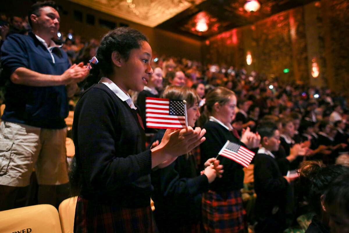 From left, Fetutuki Havili, 11, Lucrezia McClellan, 11, and Summer McGuire, 10, watch a naturalization ceremony along with other students from St. Philip the Apostle in San Francisco at the Paramont Theater in Oakland on Wednesday, May 18, 2016. Their teacher Mary McKeever spoke as the key note speaker at the ceremony. Brian Feulner, Special to the Chronicle