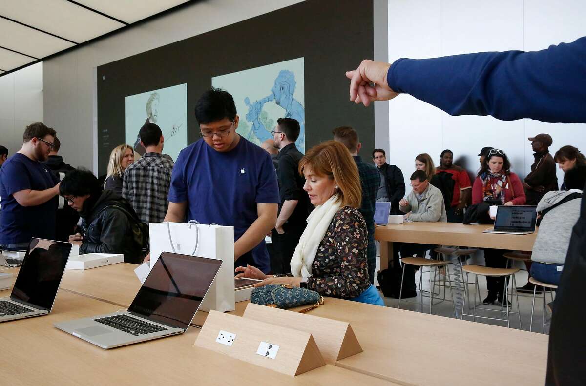 Apple employee Brent Lam, left, helps Renata Saboia set up her new iPad Pro during the opening of the new Apple store on Post and Stockton streets in Union Square May 21, 2016 in San Francisco, Calif.