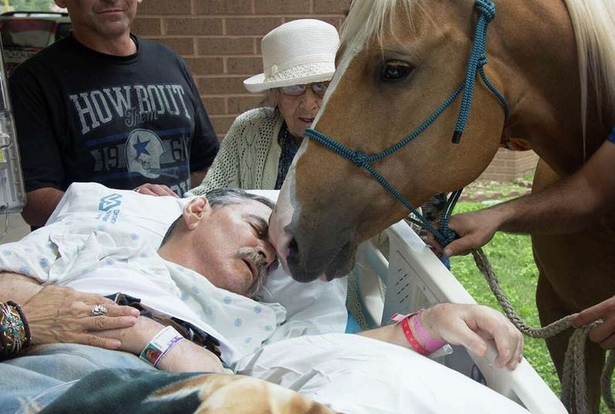 Army and Vietnam War veteran Roberto Gonzales is surrounded by family Saturday afternoon, May 21, 2016, as he receives one final visit from his beloved horses.