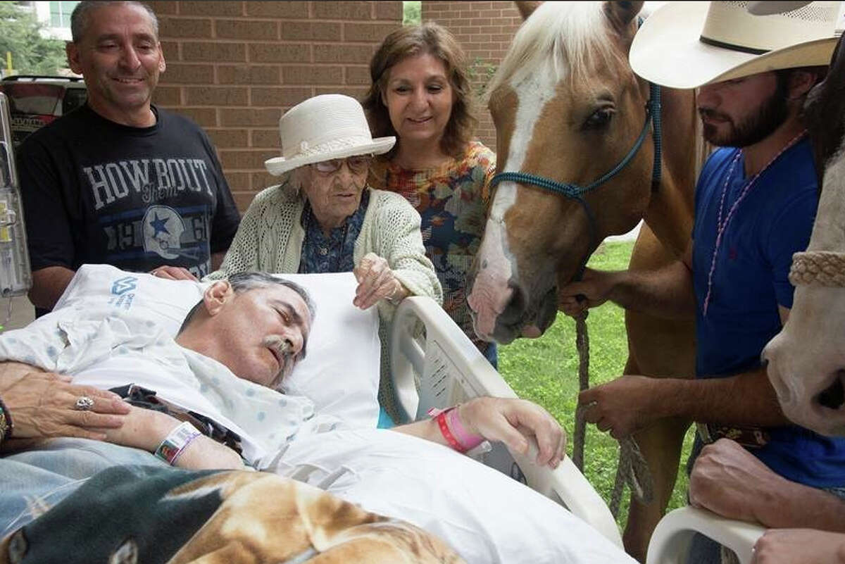 Army and Vietnam War veteran Roberto Gonzales is surrounded by family Saturday afternoon, May 21, 2016, as he receives one final visit from his beloved horses.
