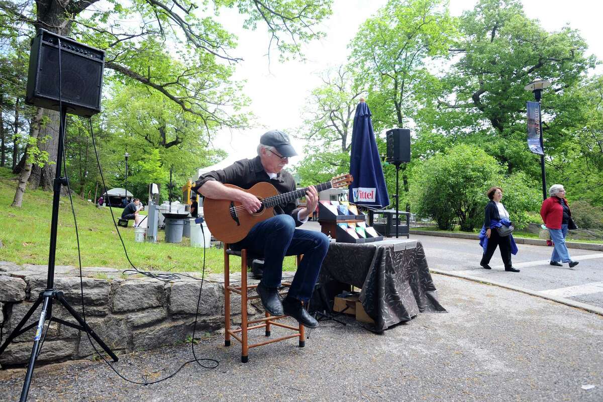 Ed Wright plays the acoustic guitar during the 31st annual outdoor crafts festival at the Bruce Museum in Greenwich, Conn. on Sunday, May 22, 2016.