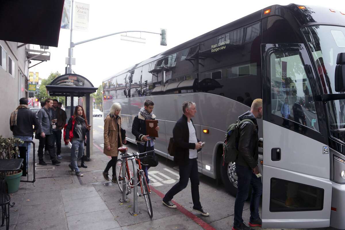 A shuttle bus bound for Silicon Valley offices more than 40 miles away picks up riders in the heart of San Francisco's Mission neighborhood, Jan. 28, 2014. The shuttle buses catering to employees of Apple, Google, Facebook and others have become a a target of ad hoc demonstrations over the gentrification squeezing many less-affluent San Franciscans out of cherished neighborhoods. 