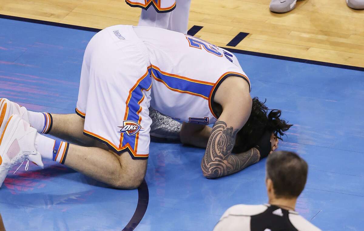 Oklahoma City Thunder center Steven Adams lies on the floor Sunday after being fouled by Golden State Warriors forward Draymond Green in the first half in Game 3 of the NBA basketball Western Conference finals in Oklahoma City.
