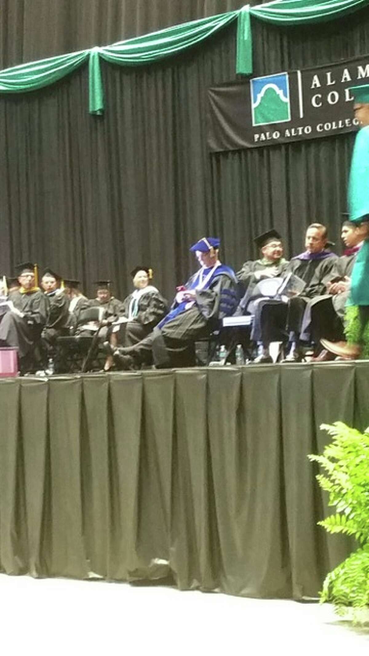 Alamo Colleges Chancellor Bruce Leslie is shown on his phone during Palo Alto College's commencement ceremony on May 21, 2016 at Freeman Coliseum.