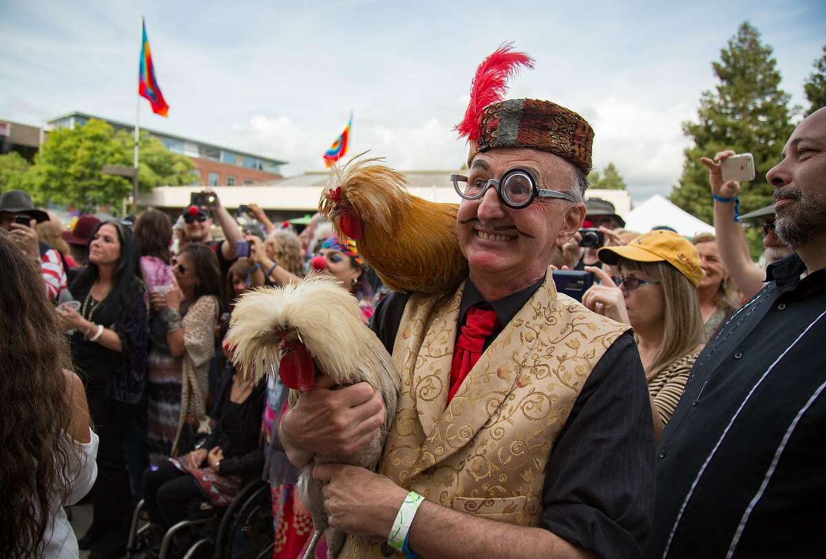 Drew Letchworth of Clown Conspiracy holds two roosters during Hugh "Wavy Gravy" Romney's 80th birthday concert and fundraiser for the Seva Foundation Sunday, May 22, 2016 at the event center at Sonoma Mountain Village in Ronhert Park, Calif. Brian Feulner, Special to the Chronicle