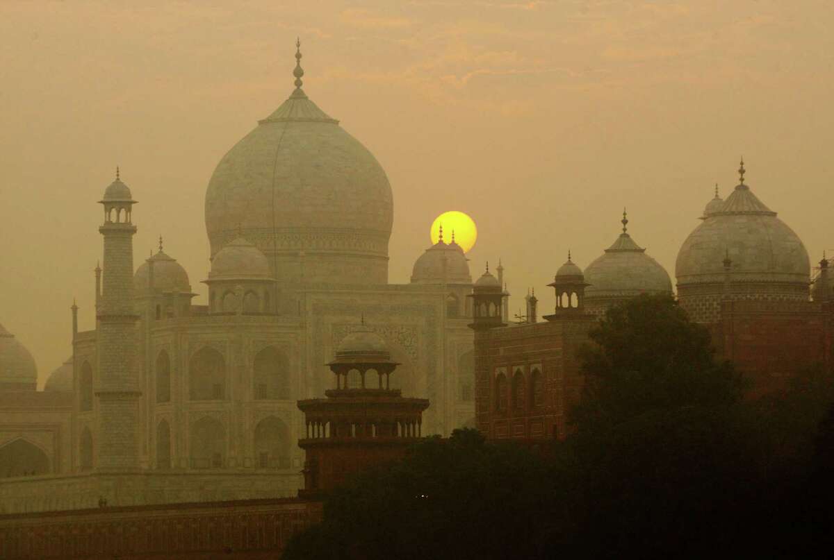 FILE - In this Nov. 18, 2009, file photo, the sun rises over the Taj Mahal in Agra, India. Archaeological experts say insects proliferating from a polluted river near the Taj Mahal are marring the intricate marble inlay work by leaving greenish black patches of waste on the walls of the 17th century monument of love. (AP Photo/Gurinder Osan, File)