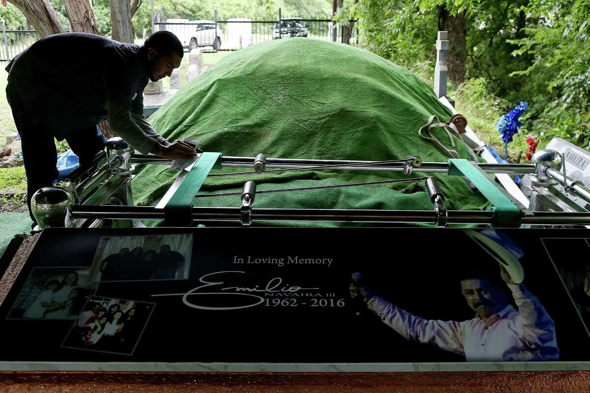 Jeremy Baxa cleans a metal frame at the burial site for Tejano music superstar Emilio Navaira, III, at San Juan Cemetery in Berg's Mill, Monday, May 23, 2016. The funeral mass will be at San Fernando Cathedral. Navaira, 53, died suddenly on May 16 at his home in New Braunfels.