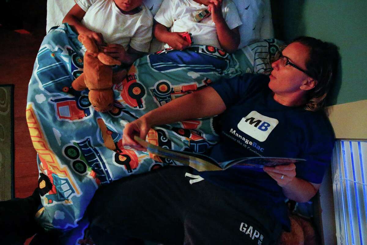 Angela Sugarek reads a book to their two foster kids, brothers ages 3 and 4, as they spend their first night back together Monday, May 23, 2016 in Houston almost two months after Child Protective Services took the kids away after they reported the youngest child was being abused by an older brother.