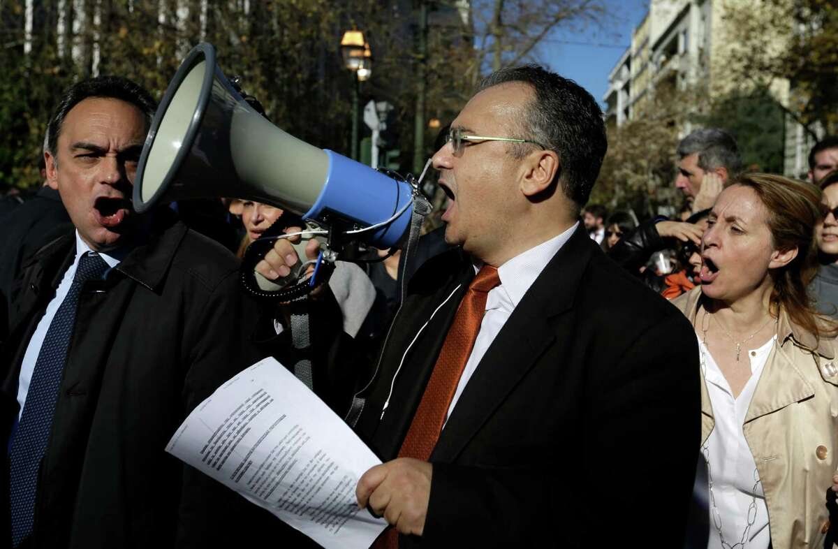 FILE - In this Thursday, Jan. 14, 2016 file photo, lawyer Dimitirs Vervesos shouts slogans with his colleagues during a rally organized by Greek Bar Associations in Athens. Several thousand people took part in the demonstration to protest the government's new social security reforms. Greek lawyers have been on strike for four months against austerity measures that impose heavy taxes on self-employed professionals. Prime minister Alexis Tsipras won a vote in parliament early Monday May 23, 2016, that will heap more taxes on a dwindling number of Greeks able to pay them. Whereas previous protests against austerity cuts drew violent street demonstrations featuring hooded youths throwing firebombs, this time itÂ?’s suited middle classes professionals revolting in whatÂ?’s been dubbed the Â?“necktie movementÂ?”. (AP Photo/Thanassis Stavrakis, File)