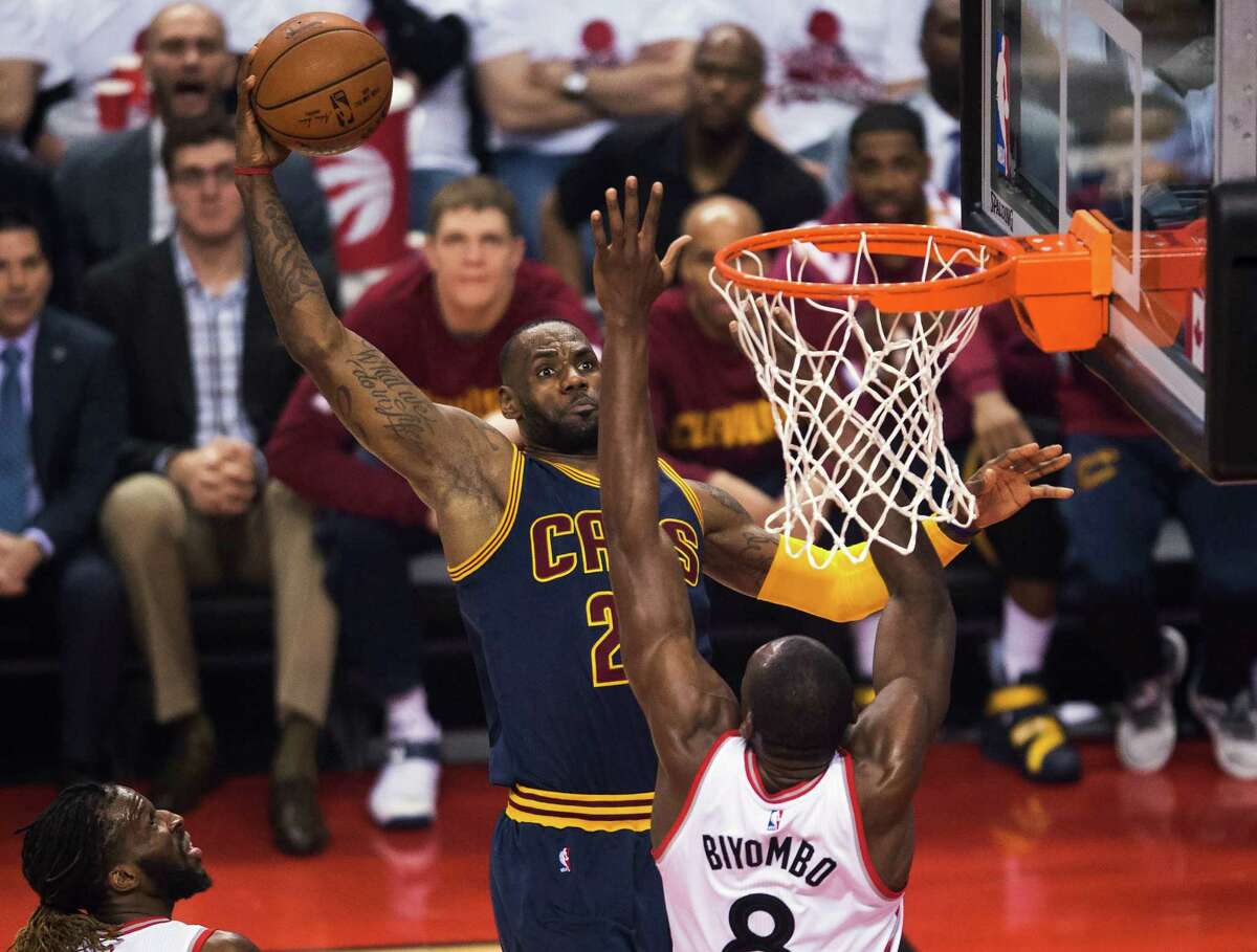 The Cavaliers' LeBron James winds up to throw one down against Bismack Biyombo, who was a strong inside presence for the Raptors with 14 rebounds and three blocked shots.