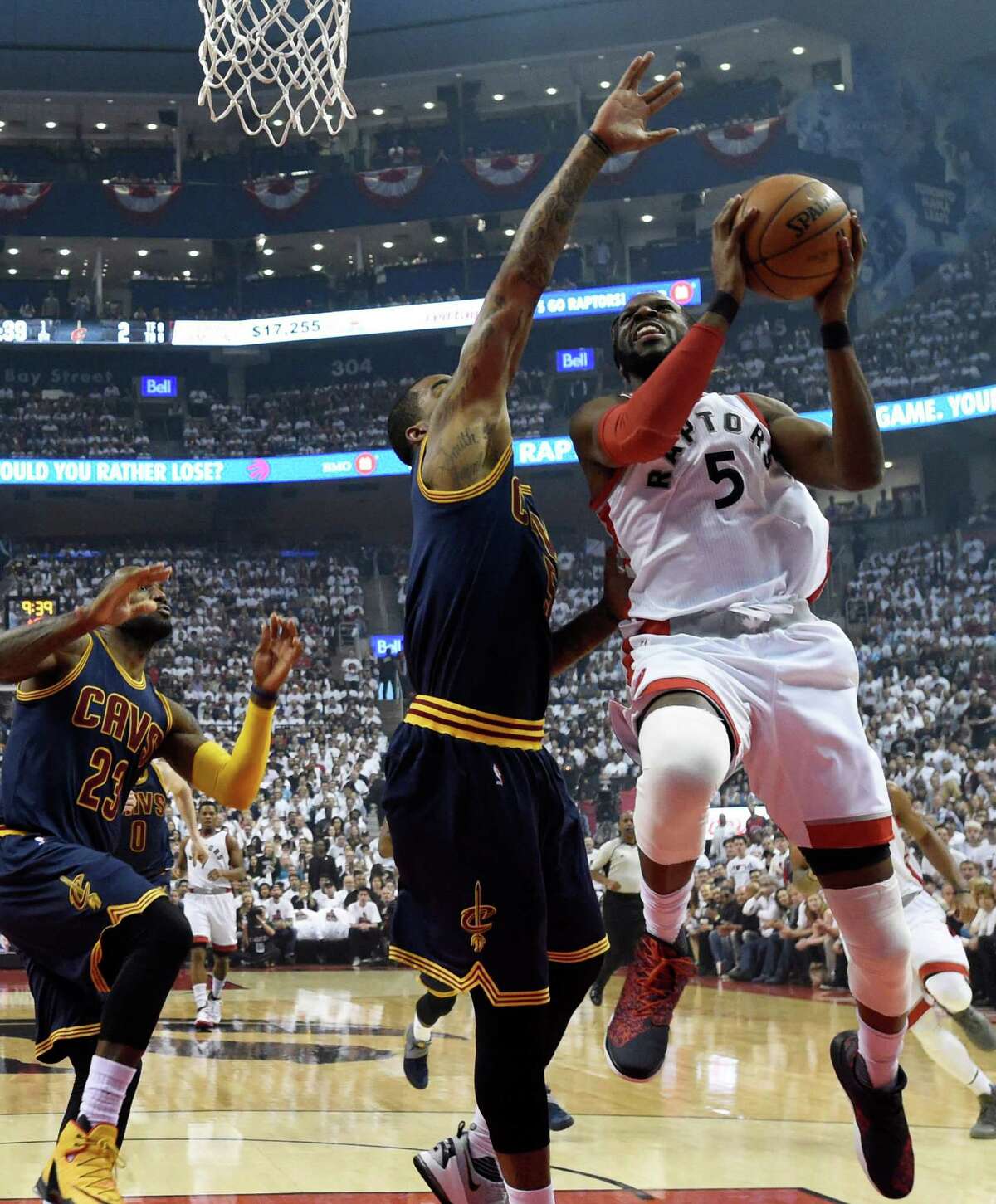 Toronto Raptors forward DeMarre Carroll (5) goes up for a shot as Cleveland Cavaliers guard-forward J.R. Smith defends during first half Eastern Conference final playoff basketball action in Toronto on Monday, May 23, 2016. Carroll made the score. (Frank Gunn/The Canadian Press via AP) MANDATORY CREDIT