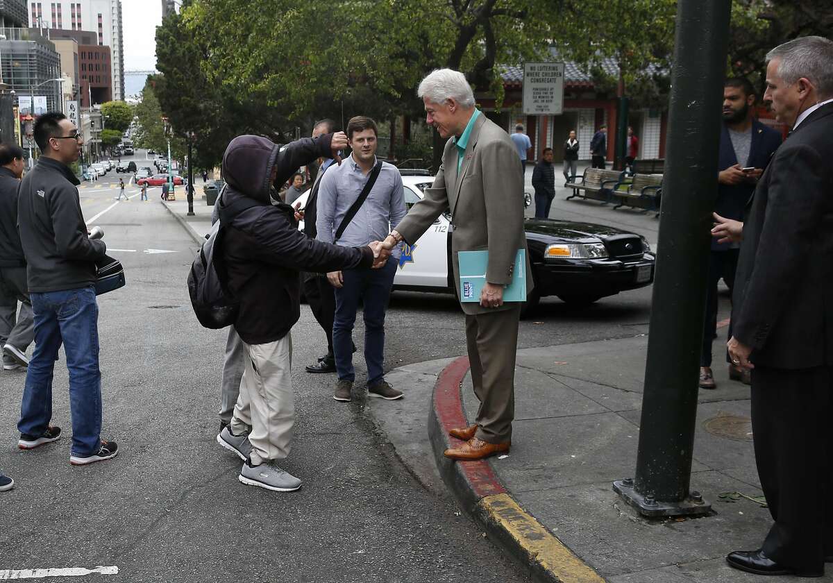 Former President Bill Clinton gets a thumbs down as he shakes hands with pedestrians during a surprise visit in Chinatown May 24, 2016 in San Francisco, Calif.