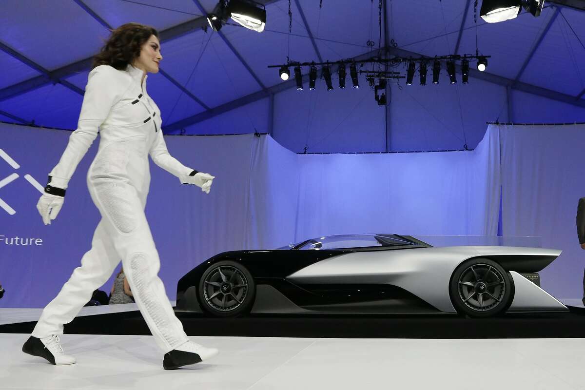 A driver walks in front of the FFZero1 by Faraday Future at CES Unveiled, a media preview event for CES International Monday, Jan. 4, 2016, in Las Vegas. The high-performance electric concept car was unveiled during a news conference by Faraday Future. (AP Photo/Gregory Bull)