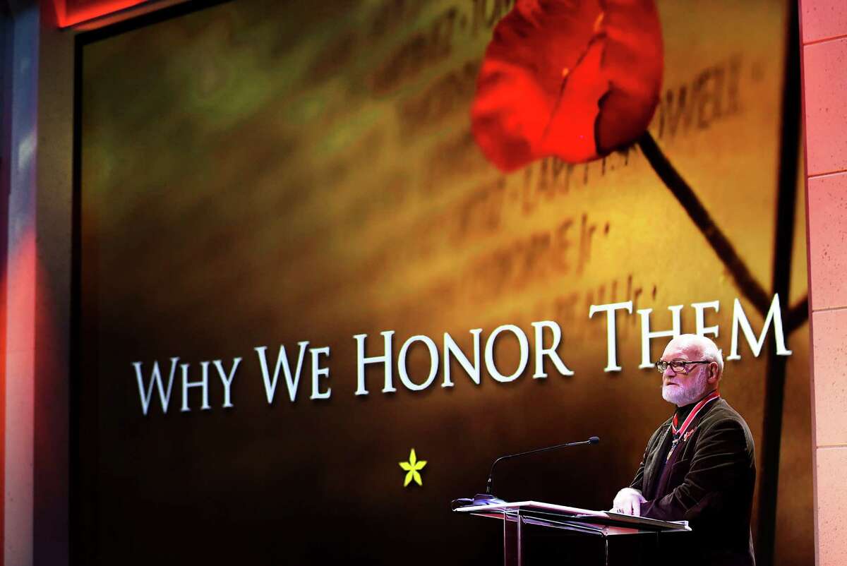 Michael Reagan, a Marine Corps Veteran and portrait artist, speaks about his military service and the portraits he has drawn for families and loved ones of those who have lost their lives in the Global War on Terror, during the USAA Memorial Day ceremony at the company's headquarters on Fredericksburg Road, on Tuesday, May 24, 2016.