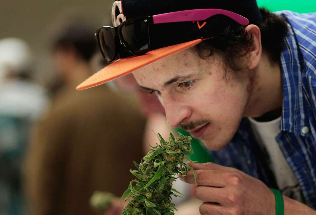ASPEN, CO - APRIL 18: A man reaches down to smell a marijuana plant at the Cannabis Crown 2010 expo in Aspen, Colorado. Cannabis Crown 2010 is hosting hundreds of marijuana-industry vendors and thousands of marijuana users in two hotels in tony Aspen, as well as holding a hemp fashion show and a marijuana-quality judging. Colorado, one of 14 states to allow use of medical marijuana, has experienced an explosion in marijuana dispensaries, trade shows and related businesses in the last year as marijuana use becomes more mainstream. (Photo by Chris Hondros/Getty Images)