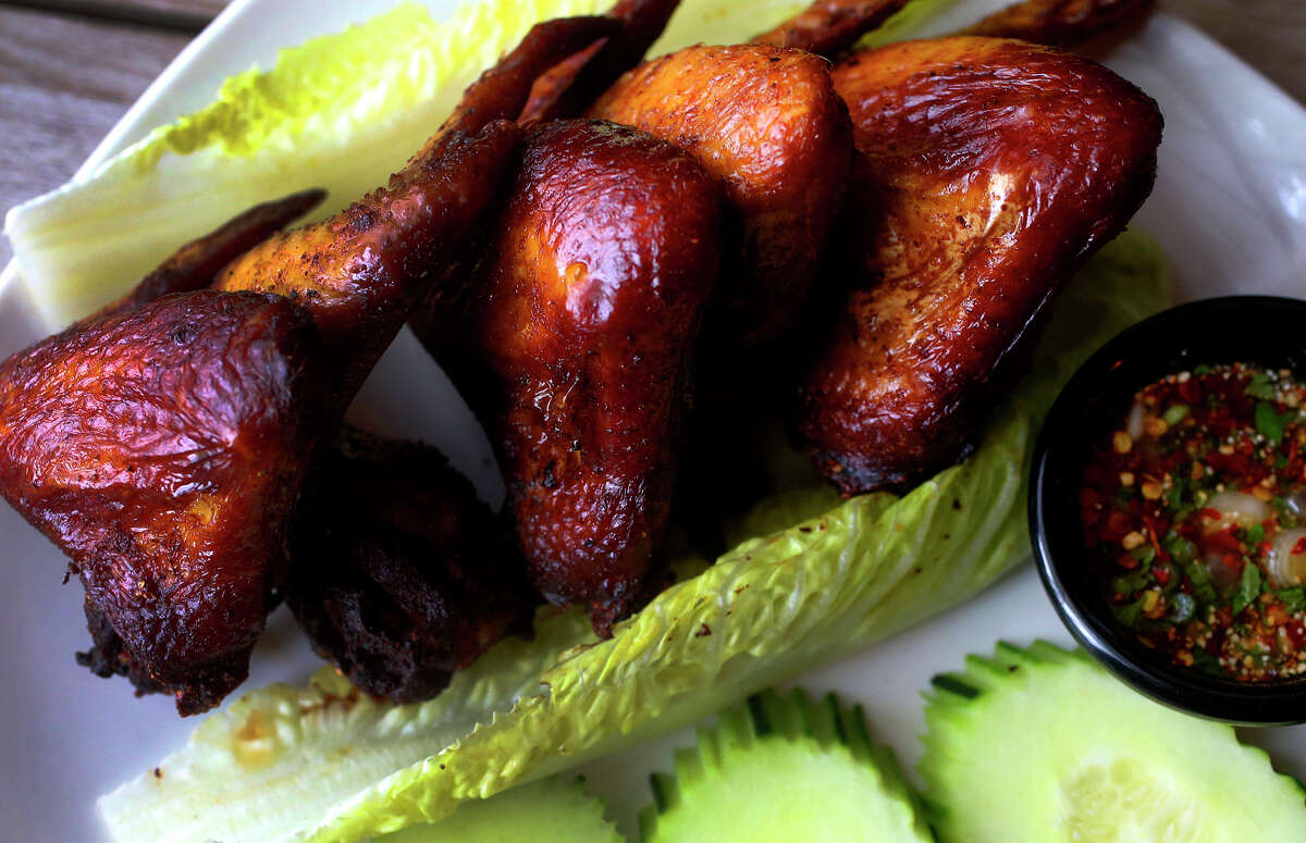 Marinated and grilled chicken wings are served with romaine lettuce and a memorable dipping sauce.