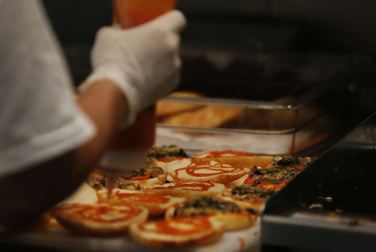 A cook prepares the buns for "burgs" (burgers) during the opening day of LocoL, which offers affordable and healthy fast food May 25, 2016 in Oakland, Calif. Chefs Roy Choi and Daniel Patterson are co-founders of the restaurant.