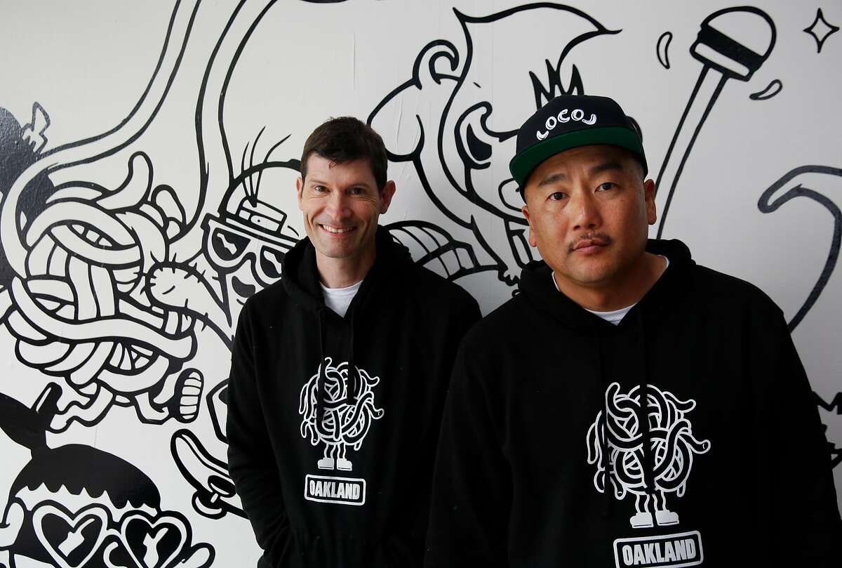 Co-founders and Chefs, from left, Daniel Patterson and Roy Choi pose next to artwork on the wall by Bradford Lynn during the opening day of LocoL, which offers affordable and healthy fast food May 25, 2016 in Oakland, Calif. Chefs Roy Choi and Daniel Patterson are co-founders of the restaurant.