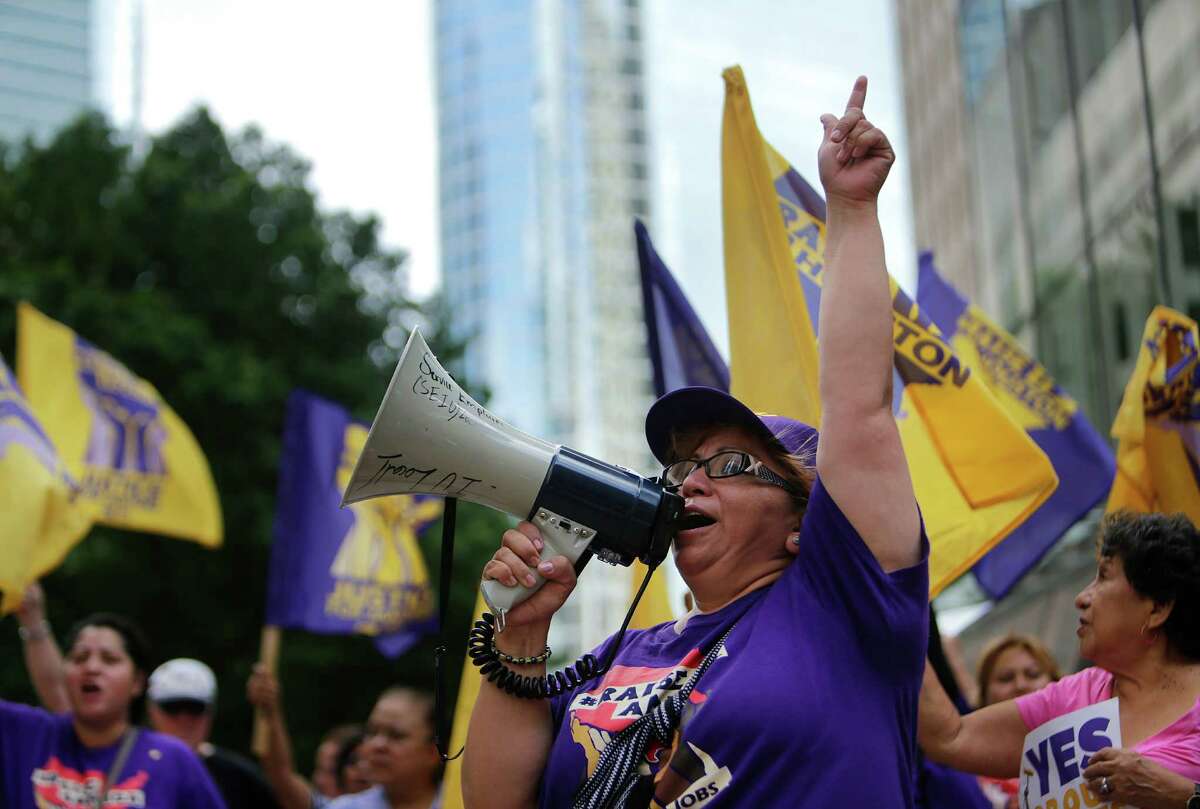 Mercedes Herrara, an organizer with SEIU, leads a chant during a rally in front of One Allen Center on Wednesday.