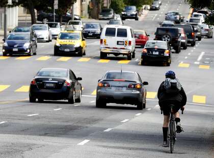 Cars and a bicyclist drive on Masonic Avenue between Fell Street and Geary Boulevard in San Francisco, California, on Wednesday, May 25, 2016.